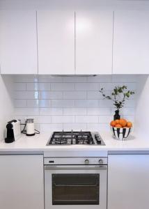 马塔卡纳Garden Apartment的白色的厨房配有炉灶和一碗橙子