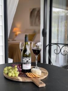 una bottiglia di vino e un bicchiere su un tavolo di Garden Apartment a Matakana