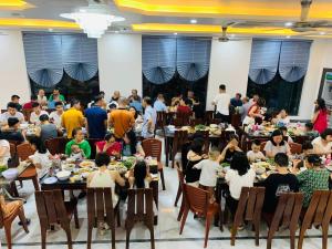 a crowd of people sitting at tables in a banquet hall at Khách Sạn Đại Dương FLC Sầm Sơn in Sầm Sơn