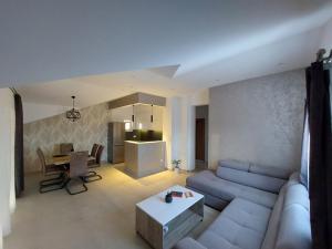 ein Wohnzimmer mit einem Sofa und einem Tisch in der Unterkunft LightHouse Apartments in Tivat