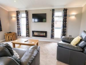 a living room with a couch and a fireplace at Callow Lodge 15 in Hadnall