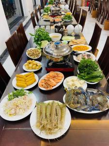 岑山的住宿－Khách Sạn Đại Dương FLC Sầm Sơn，一张长桌,上面放着许多盘子的食物