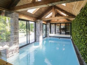 a swimming pool in a house with a wooden ceiling at Bryn Derwen in Bangor