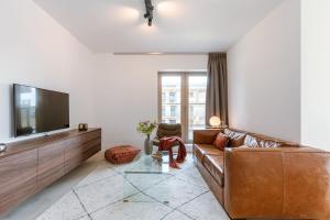uma sala de estar com um sofá e uma televisão de ecrã plano em Beautifully decorated apartment with sunny terrace em Oostende
