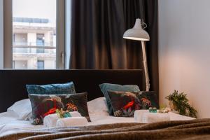 um quarto com uma cama com almofadas e um candeeiro em Beautifully decorated apartment with sunny terrace em Oostende