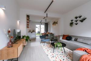 een woonkamer met een bank en een tafel bij Beautiful modern holiday house with private garden in Bredene