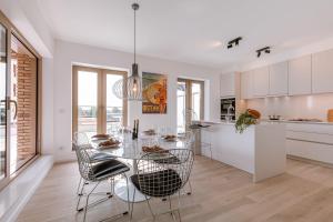 uma cozinha e sala de jantar com uma mesa de vidro e cadeiras em Beautifully decorated apartment with sunny terrace em Oostende