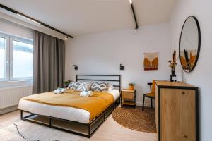 1 dormitorio con cama y espejo en Beautiful modern holiday house with private garden, en Bredene