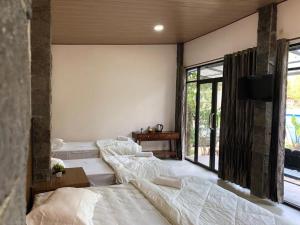 a bedroom with three beds and a tv on a wall at Bromo Camp House in Bromo