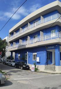 a blue building with cars parked in front of it at Sonia Hotel & Suites in Kos Town