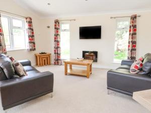 a living room with two couches and a tv at Callow Lodge 22 in Hadnall