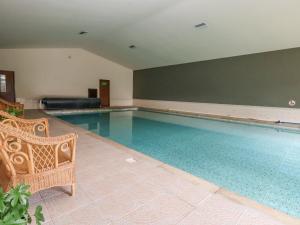 a large swimming pool with a chair in a room at Callow Lodge 22 in Hadnall