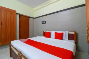 a bedroom with a bed with red and white pillows at SPOT ON Raja Lodge in Tiruvannāmalai