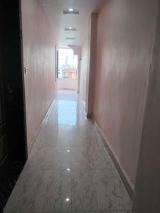 un pasillo vacío con una habitación con paredes rosas en OYO 81285 Hotel Chanda en Madhubani
