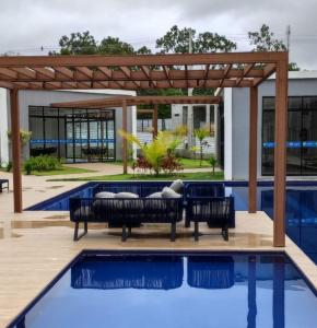 eine Pergola über einem Swimmingpool mit Terrasse in der Unterkunft Garden Ipojuca Caruaru in Caruaru