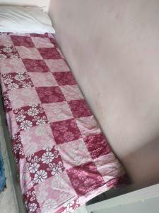 a bed with a pink and white quilt on it at OYO 81285 Hotel Chanda in Madhubani