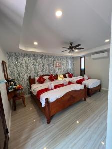 a bedroom with two beds and a ceiling fan at Golden Lotus Namkhan River View in Luang Prabang