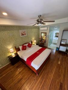 a bedroom with a large bed and a ceiling fan at Golden Lotus Namkhan River View in Luang Prabang