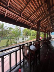 a restaurant with a table and chairs and a large window at Golden Lotus Namkhan River View in Luang Prabang