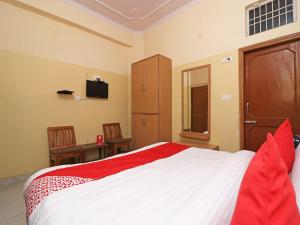 um quarto com uma cama e uma televisão na parede em OYO 24103 AKBAR PALACE em Alīgarh