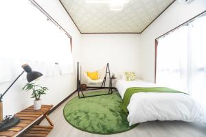 a bedroom with two beds and a green rug at Yokkaichi Kawaramachi Hotel in Hazu