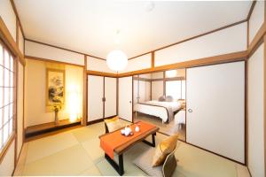 a bedroom with a bed and a table in a room at Yokkaichi Kawaramachi Hotel in Hazu