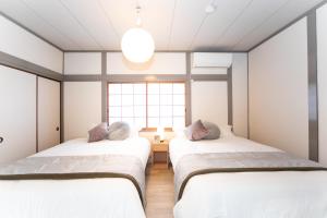 two beds in a room with a window at Yokkaichi Kawaramachi Hotel in Hazu +34 photos