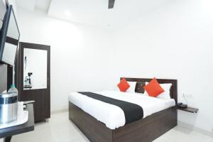 a bedroom with a bed with orange and black pillows at Hotel Star Inn in Karnal