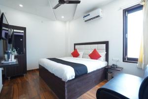 sypialnia z dużym łóżkiem z czerwonymi poduszkami w obiekcie Hotel Star Inn w mieście Karnal