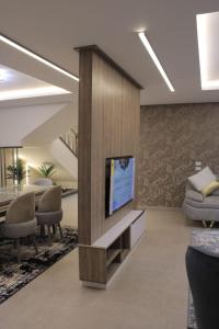 sala de estar con TV de pantalla plana en la pared en فيلا نادي الزمالك برج الشرطه 1 en Kafr Abū ʼumaydah