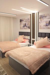 2 camas en una habitación con pinturas en la pared en فيلا نادي الزمالك برج الشرطه 1, en Kafr Abū ʼumaydah