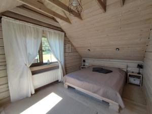 ein Schlafzimmer mit einem Bett in einem Holzzimmer in der Unterkunft GREY PINE HOUSE in Druskininkai