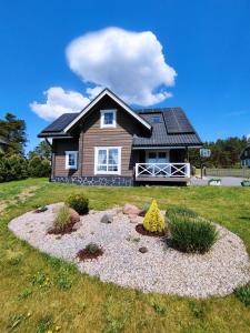 ein Haus mit einem Kiesgarten davor in der Unterkunft GREY PINE HOUSE in Druskininkai
