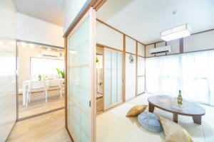 Zimmer mit einem Tisch und einem Esszimmer in der Unterkunft Yokkaichi Kawaramachi Hotel in Hazu