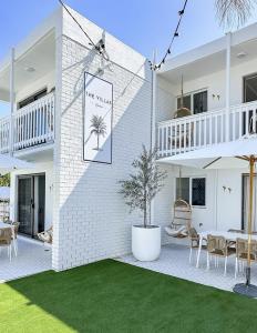 a white brick house with a palm tree sign on it at The Villa's Mooloolaba in Mooloolaba
