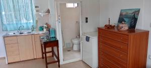 a bathroom with a sink and a toilet and a dresser at Jasmine's Guest House in Karlovasi