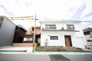 a white house in the middle of a street at Yokkaichi Kawaramachi Hotel in Hazu