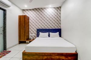 1 dormitorio con 1 cama con cabecero azul en Capital O Hotel City Inn, en Amritsar