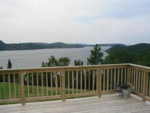 a wooden deck with a view of the water at The View Lodgings in Princeton