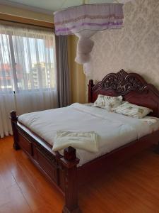 ein Schlafzimmer mit einem großen Bett mit weißer Bettwäsche in der Unterkunft the heavenly apartments along Dennis prit road. in Nairobi