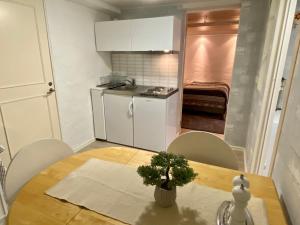 una pequeña cocina con mesa, mesa y sillas en Lower floor of 50 sqm in nice villa with parking en Estocolmo
