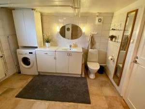 a bathroom with a sink and a washing machine at Lower floor of 50 sqm in nice villa with parking in Stockholm