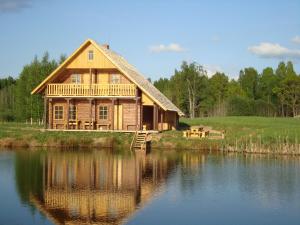a large wooden house on the edge of a lake at Līgatnes Zemturi in Augšlīgatne
