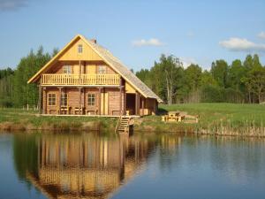 a large wooden house on the edge of a lake at Līgatnes Zemturi in Augšlīgatne