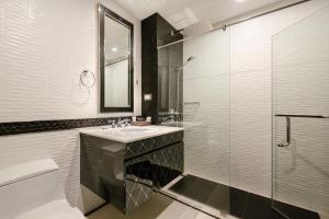 a bathroom with a sink and a glass shower at Sirin Exclusive Hotel and Residence in Pattaya South