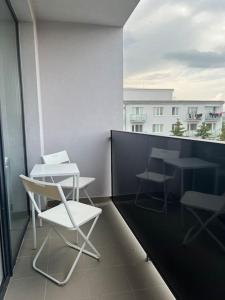 a balcony with a table and chairs on a building at Apartmán Centrum s parkovaním in Košice +2 photos