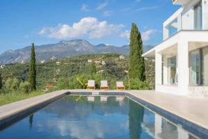 une maison avec une piscine avec des montagnes en arrière-plan dans l'établissement Villa Sadova Private pool Panoramic view, à Kalamata