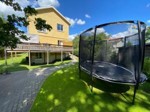 a swing in the grass in front of a house at Lower floor of 50 sqm in nice villa with parking in Stockholm
