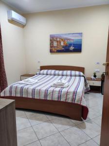 a bedroom with a bed and a painting on the wall at TropeaCharmet PARKING FREE in Tropea