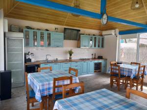 a kitchen with blue cabinets and tables and chairs at Stuffino Crisan in Crisan